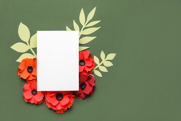 Blank paper sheet with poppy flowers and leaves on green background