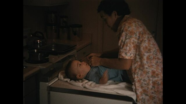 Standing Up Baby 1968 - A mother stands her baby up for camera while in the kitchen in the 1960s
