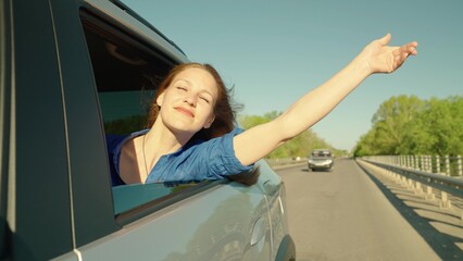 Auto travel on road on vacation, Free young girl waved her hand from car window, travels, catches...