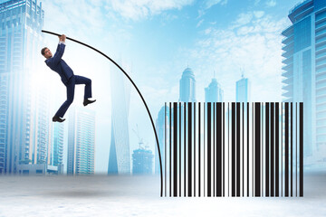 Businessman jumping over bar code in pole vaulting