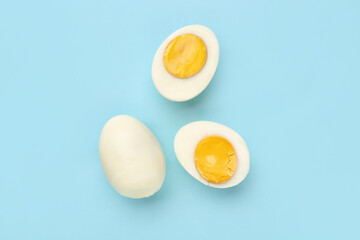Delicious boiled eggs on blue background