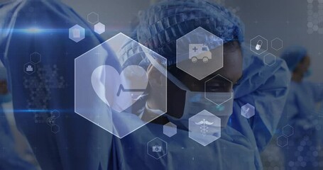 Animation of medical icons over biracial female surgeon wearing surgical mask at hospital