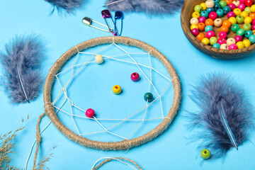 Materials for making dream catcher on blue background, closeup