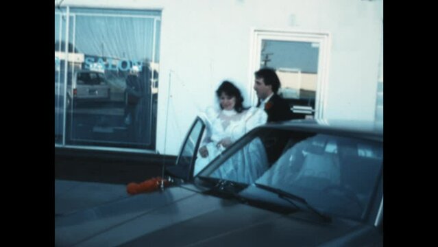 Just Married 1985 - Newlyweds enter the family sedan and drive off of the parking lot in the 1980s