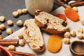 Delicious biscotti cookies, hazelnuts and dried apricots on napkin, closeup