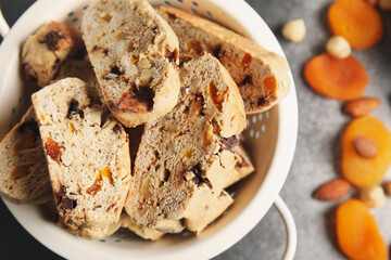 Bowl with delicious biscotti cookies on grunge background, closeup