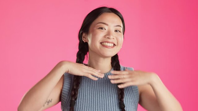 Happy, posing and face of asian woman in studio for positive, peace sign and frame. Focus, emoji and finger heart with girl and hand gestures on pink background for photography and satisfaction