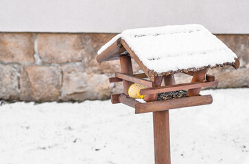 View of wooden bird house covered with snow on winter day, closeup