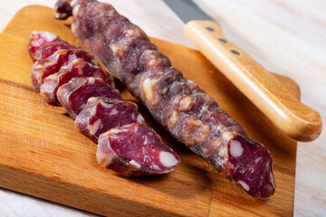 Traditional french dry cured sausage on wooden table