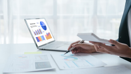 Using calculator and laptop, Close up hands of asian bookkeeper female working with stack of papers and balance sheet with bureaucracy hardworking in office desk.