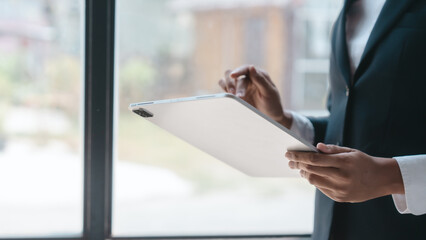 Using tablet pc, Close up hands of asian bookkeeper female working with stack of papers and balance sheet with bureaucracy hardworking in office desk.