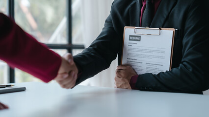 Shaking hands, Close up view of job interview with applicant with resume paper in office, Recruitment, Job application concept.