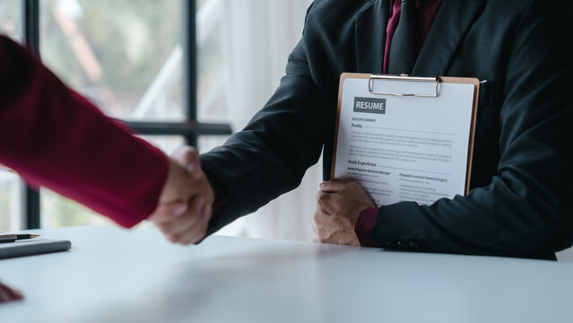 Shaking hands, Close up view of job interview with applicant with resume paper in office, Recruitment, Job application concept.