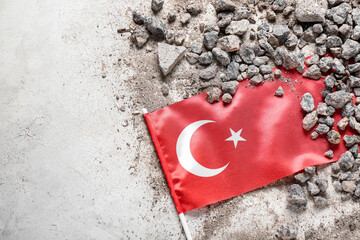 Stone debris with Turkish flag on light background. Turkey earthquake concept