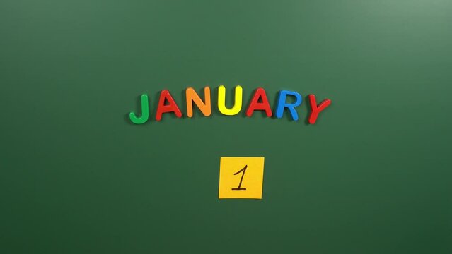 Hand sticking a sticker 1 January calendar day on school board. 1 date of January. First day of January. 1st date number. 1 day calendar. One date