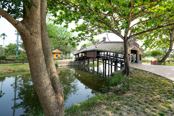 Fototapeta na wymiar Thanh Toan Ancient Tiled Bridge is a wooden bridge with tiled roofs spanning a ditch in Thanh Thuy Chanh village, about 8 km southeast of Hue city, central Vietnam.