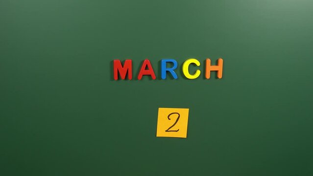 Hand sticking a sticker 2 March calendar day on school board. 2 date of March. Second day of March. 2nd date number. 2 day calendar. Two date. Ethiopia Victory at Adwa