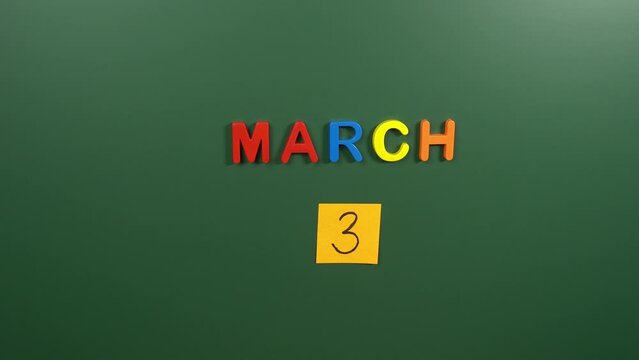 Hand sticking a sticker 3 March calendar day on school board. 3 date of  March. Third day of March. 3rd date number. 3 day calendar. Three date.  Liberation Bulgaria
