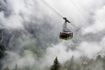 cable car in Lauterbrunnen valley with fog and mountains