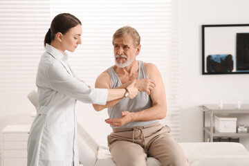 Obraz premium Orthopedist examining patient with injured arm in clinic