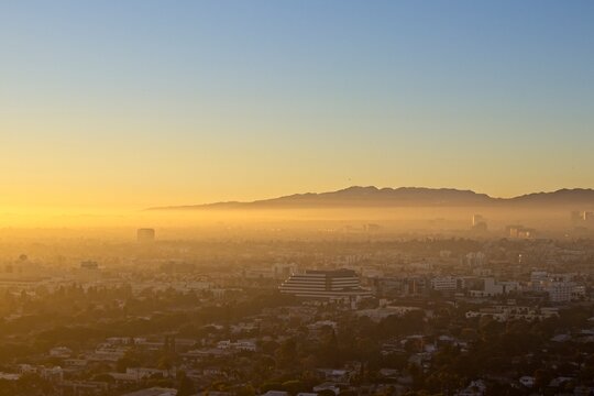 Fog from the ocean rolls over LA's Westside as the sun sets over the Pacific, obscured by the marine layer