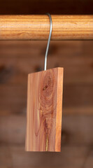 Aromatic cedar block hanging on a closet on  wood background.