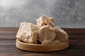 Pieces of compressed yeast on wooden table