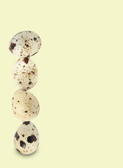 Stacked speckled quail eggs on light beige background. Space for text
