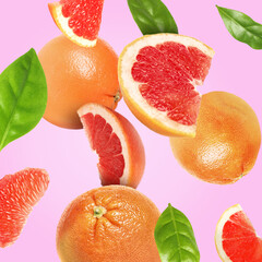 Cut fresh grapefruits and green leaves flying on pale violet background