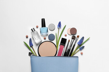 Flat lay composition with different makeup products and beautiful flowers on white background