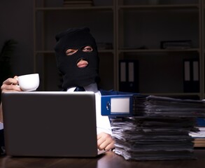 Male employee stealing information in the office night time