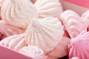 Pink meringue cookies with berries in a box