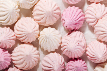 Pink meringue cookies with berry flavor on baking parchment