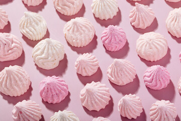 Pink meringue cookies with berry flavor on a pink background