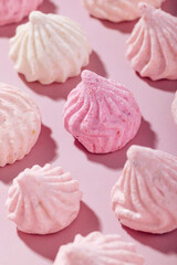 Pink meringue cookies with berry flavor on a pink background