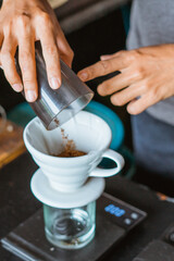 close up of hand making a coffee with filter on the glass