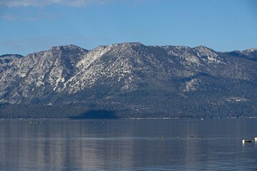 Parasailers and boaters begin their mornings on the peaceful waters of Lake Tahoe in the Sierra Nevada Mountains.
