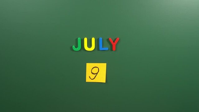 Hand sticking a sticker 9 July calendar day on school board. 9 date of July. Ninth day of July. 9th date number. 9 day calendar. Nine date. Argentina independence