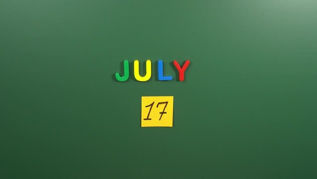 Hand sticking a sticker 17 July calendar day on school board. 17 date of July. Seventeenth day of July. 17th date number. 17 day calendar. Seventeen date. Emoji, International Justice, National Tattoo