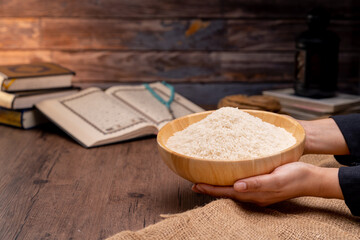 Hands are holding a pile of grain to zakat, the Islamic zakat concept. Muslims help the poor and needy. Conceptual shoot for property, income, and fitrah zakat.