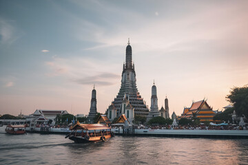 Fototapeta na wymiar Wat Arun at sunset with long tail boat, in Bangkok, Thailand. Generative AI