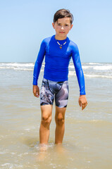 Fototapeta na wymiar Male teenager youth swimmer standing in the water at the beach