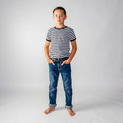 Preteen male boy wearing a striped shirt and jeans standing with hands in pockets © 3Days2Go Media