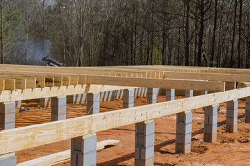 Work on new custom homes concrete block foundation installing wood floor joists trusses