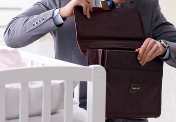Young businessman trying to work from home caring after newborn