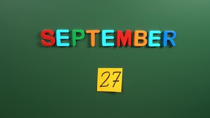 Hand sticking a sticker 27 September calendar day on school board. 27 date of September. Twenty seventh day of September. 27th date number. 27 day calendar. Twenty seven date. World Tourism