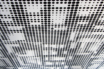 Metal ceiling. Perforated panels of suspended ceiling. Office building interior fragment. Abstract background textures on the subject of modern architecture or construction industry. Strong durable.