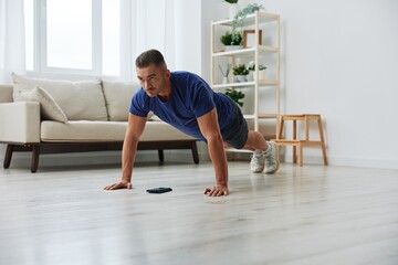 Fototapeta premium Man sportsman training at home, stretching exercises for arm, leg and back muscles, strong body and correct posture, the concept of health and beauty