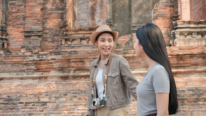 Fototapeta na wymiar Two Asian women enjoyment in the old town. Phra Nakhon Si Ayutthaya, Thailand. Traveling on holidays