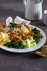 pecal or Indonesian salad is a boiled vegetables topping with tofu, tempeh, peanut sauce and crackers
